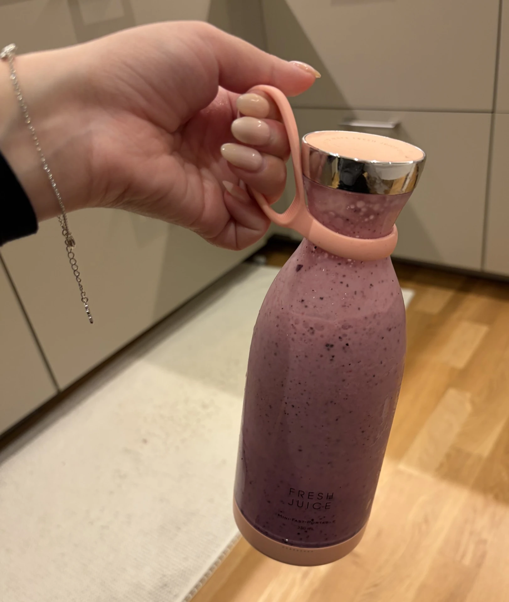 Verifierad kund håller BLENZA fylld med bärsmoothie i köket