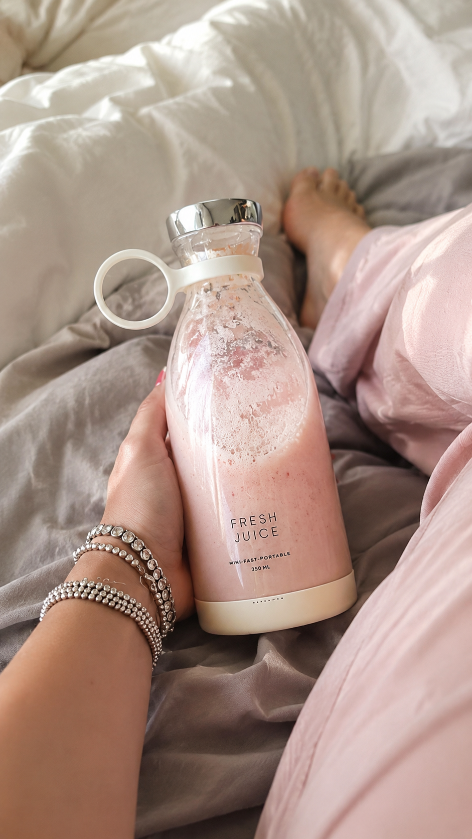 Verifierad kund håller BLENZA i sängen med ljusrosa smoothie